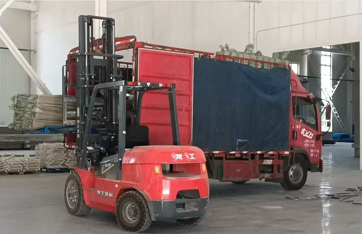 Factory forklift loading pallets of packaged carbon fiber walking canes onto logistics truck
