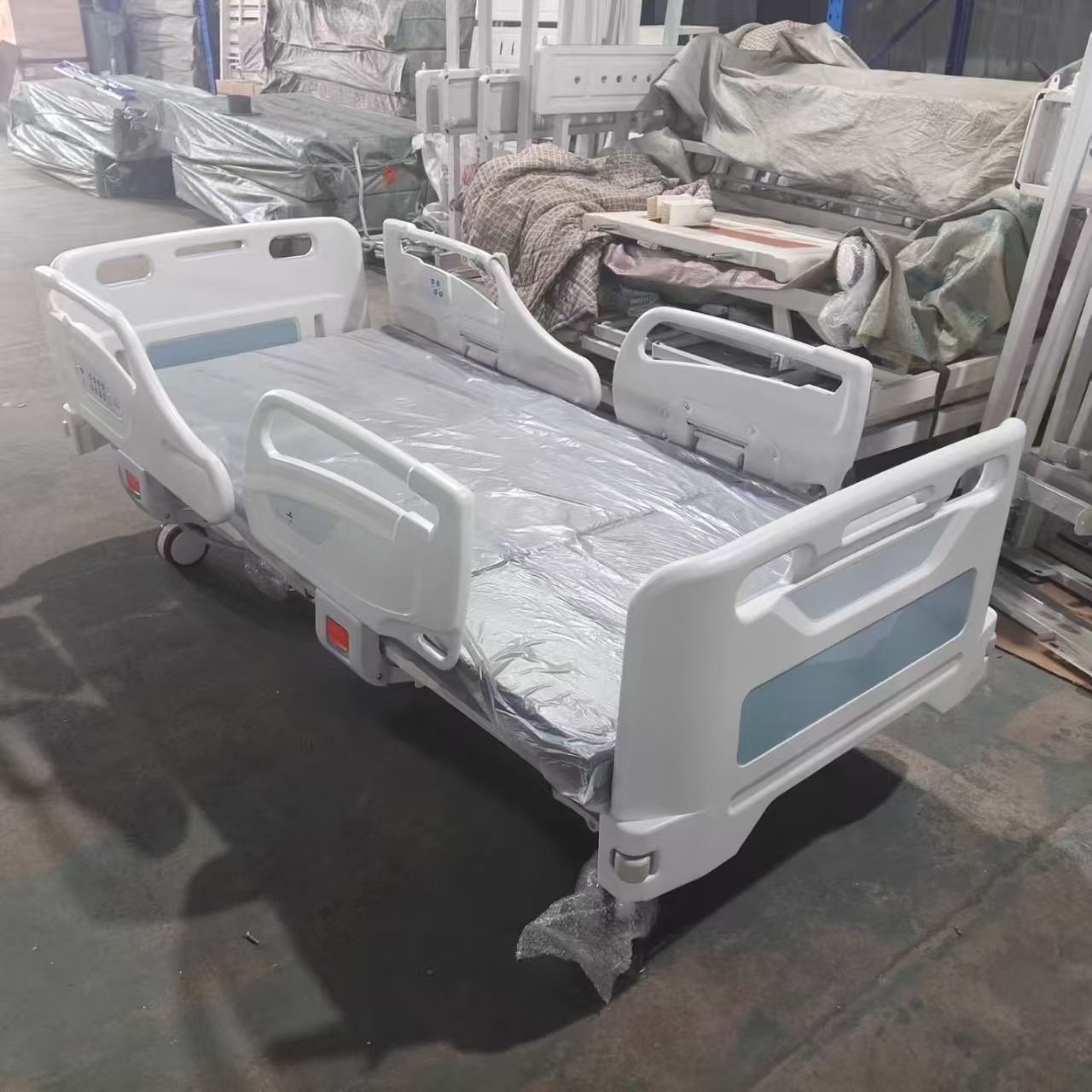 Flat deck position of electric ICU hospital bed showing corner bumper wheels and native ABS end boards
